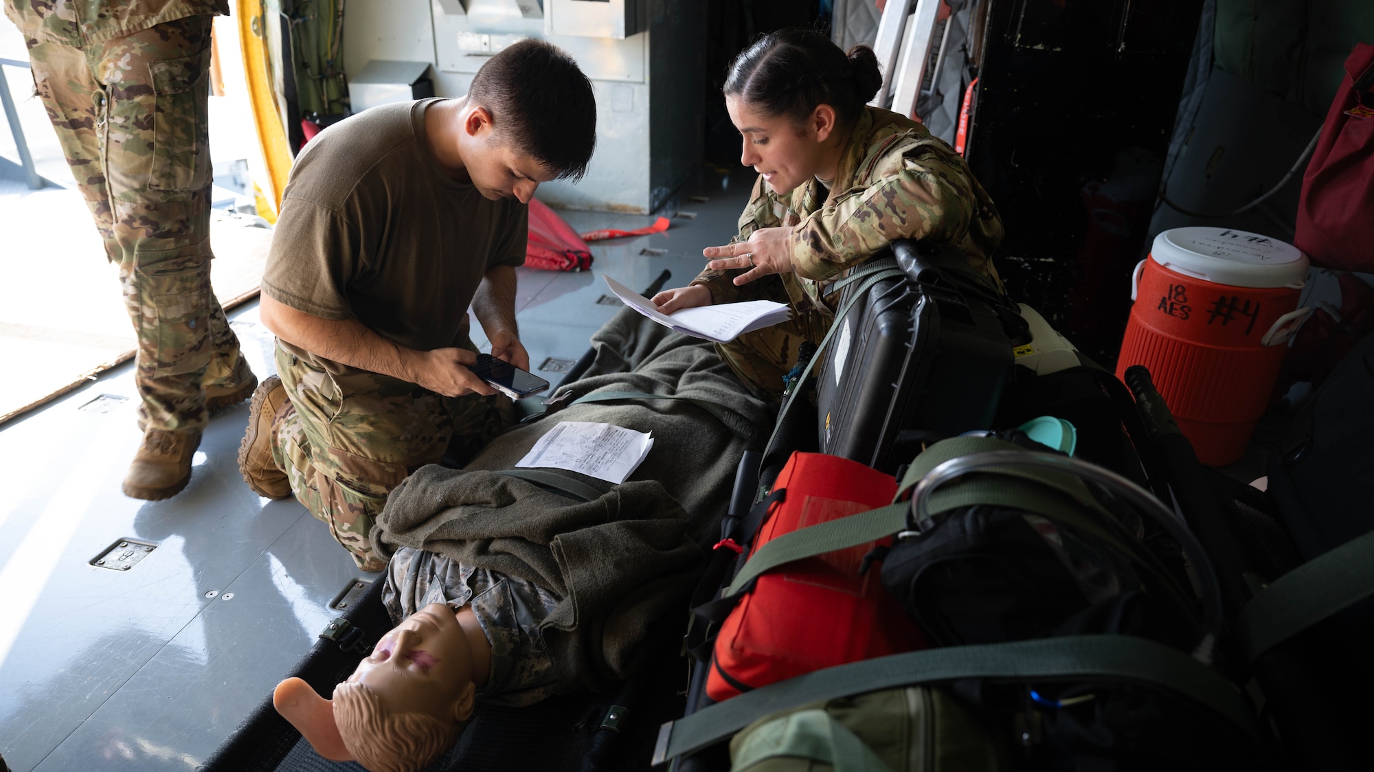 Airman from the 18th AES check on a simulated patient before take off