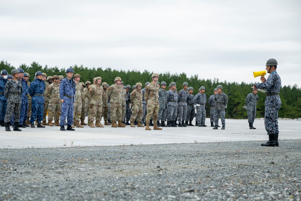 U.S. Airmen assigned to the 35th Civil Engineer Squadron, and Japanese Armed Forces muster for a safety brief prior to a bilateral rapid airfield damage repair exercise as part of Keen Sword 25 at Draughon Range near Misawa Air Base, Japan, Oct. 30, 2024.