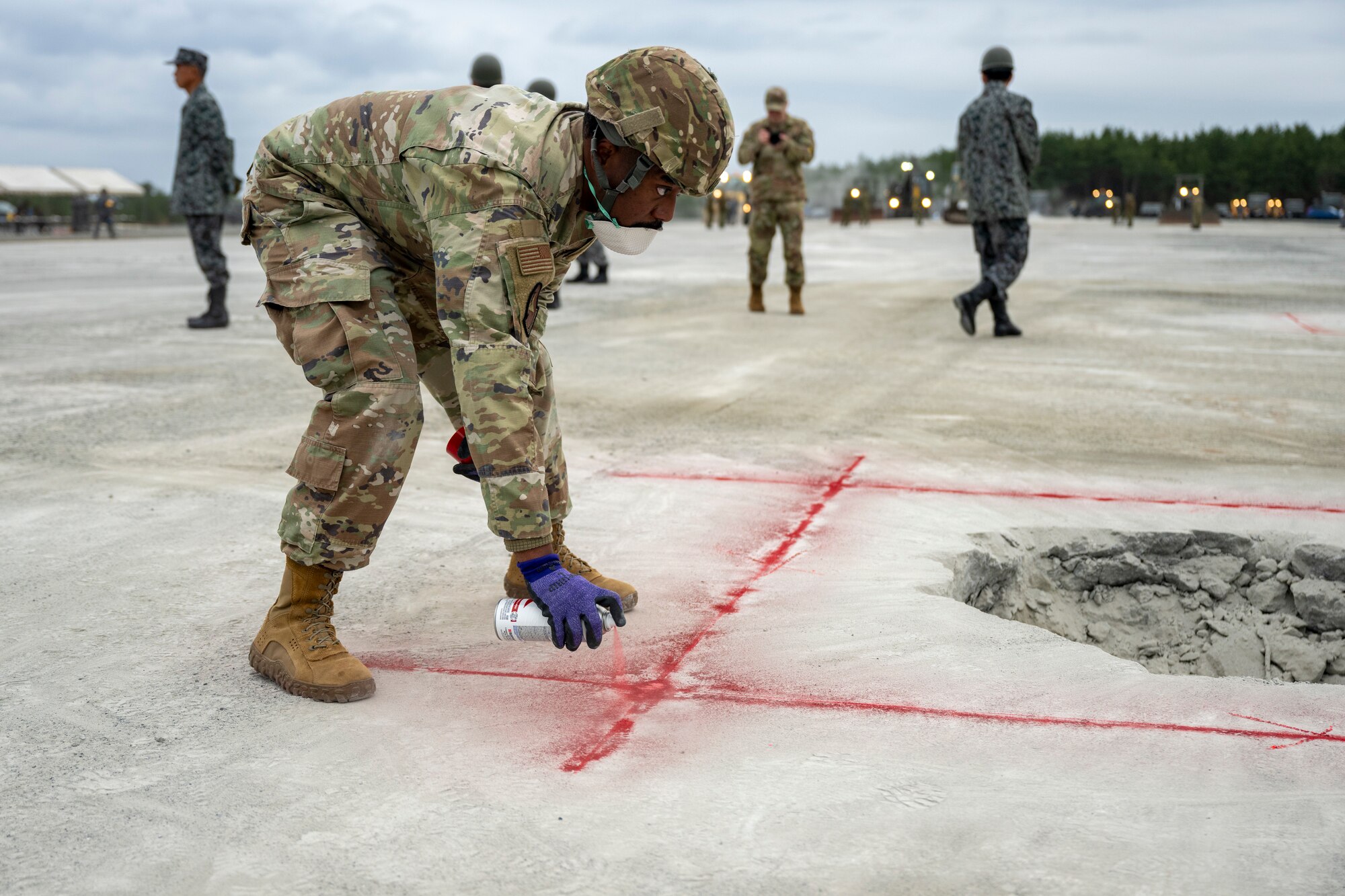 U.S. Airmen assigned to the 35th Civil Engineer Squadron, and Japanese Armed Forces muster for a safety brief prior to a bilateral rapid airfield damage repair exercise as part of Keen Sword 25 at Draughon Range near Misawa Air Base, Japan, Oct. 30, 2024.