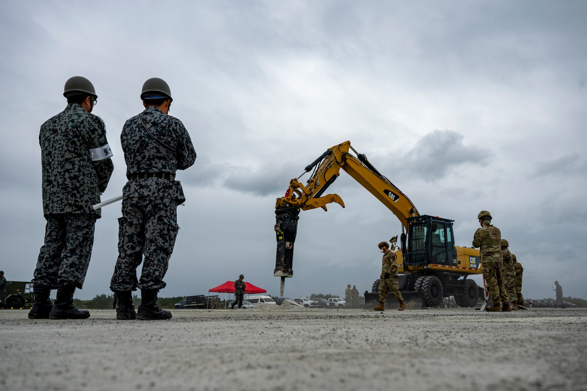 U.S. Airmen assigned to the 35th Civil Engineer Squadron, and Japanese Armed Forces muster for a safety brief prior to a bilateral rapid airfield damage repair exercise as part of Keen Sword 25 at Draughon Range near Misawa Air Base, Japan, Oct. 30, 2024.