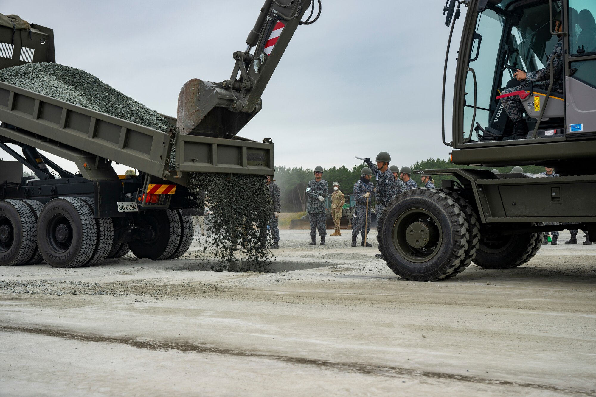 U.S. Airmen assigned to the 35th Civil Engineer Squadron, and Japanese Armed Forces muster for a safety brief prior to a bilateral rapid airfield damage repair exercise as part of Keen Sword 25 at Draughon Range near Misawa Air Base, Japan, Oct. 30, 2024.