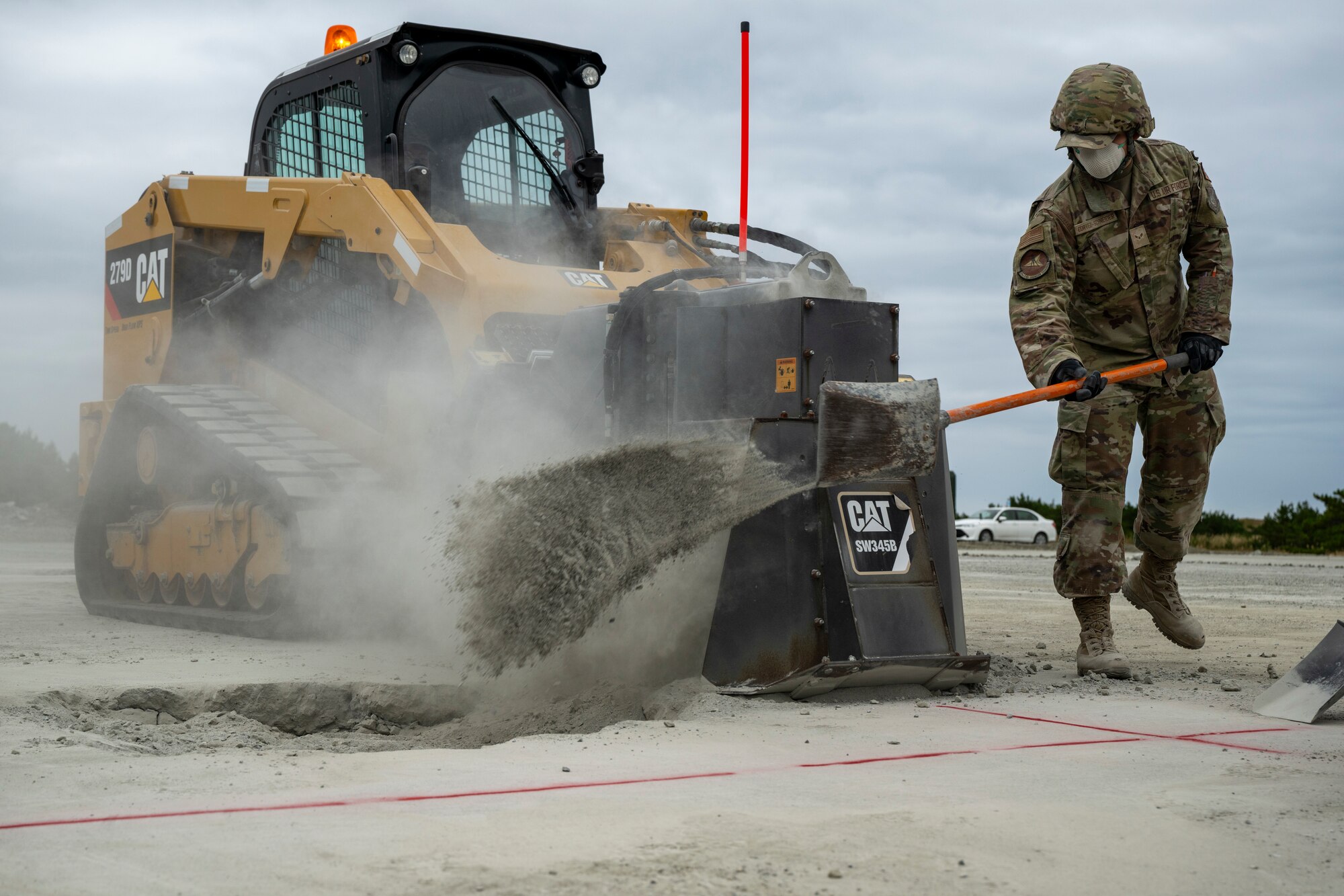 A U S Air Force Airman shovels debris into a crater