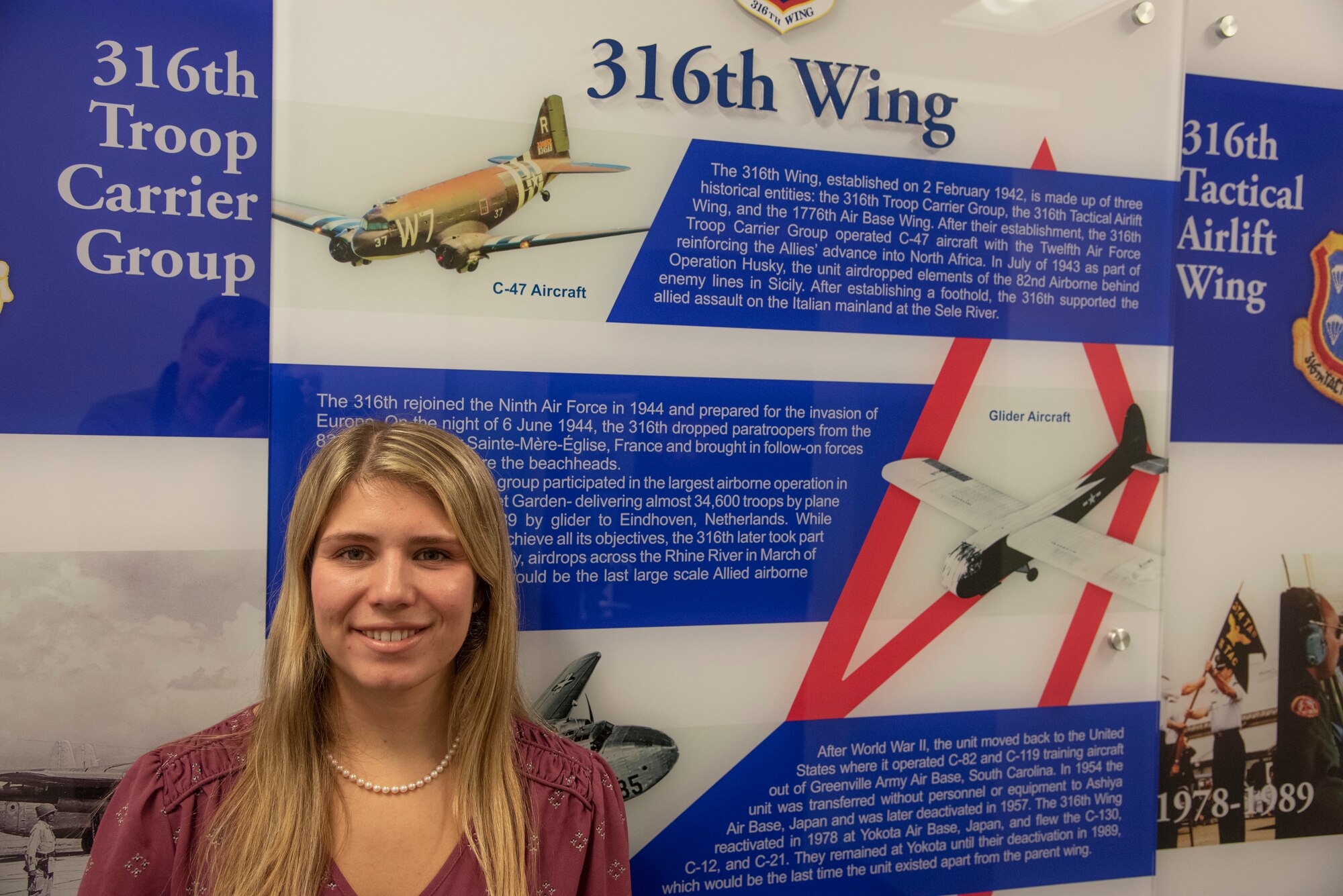 Meaghan M. Kacmarcik, the 316th Wing deputy historian, stands in front of a display showcasing the wing’s history in the Jones Building at Joint Base Andrews, Md., Oct. 24, 2024. After joining the historian office in January 2024, Kacmarcik has used her passion for history to uncover, research and archive key moments within the 316th Wing and Joint Base Andrews. (U.S. Air Force photo by Patrick Griffith)