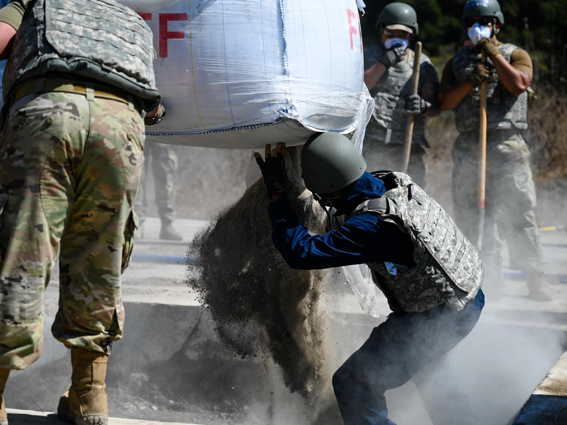 A Civil Engineer Squadron member opens a bag of concrete during a Rapid Airfield Damage Repair training at Vandenberg Space Force Base, Calif., Sept. 26, 2024. The Prime Base Engineer Emergency Force training day focuses on training core competencies in a setting mimicking a deployed environment. Vandenberg’s 30th CES, 21st CES from Peterson Space Force Base, and 61st Civil Engineer and Logistics Squadron members from Los Angeles Air Force Base trained on core civil engineer competencies in a setting mimicking a deployed environment. (U.S. Space Force photo by Senior Airman Joshua LeRoi)