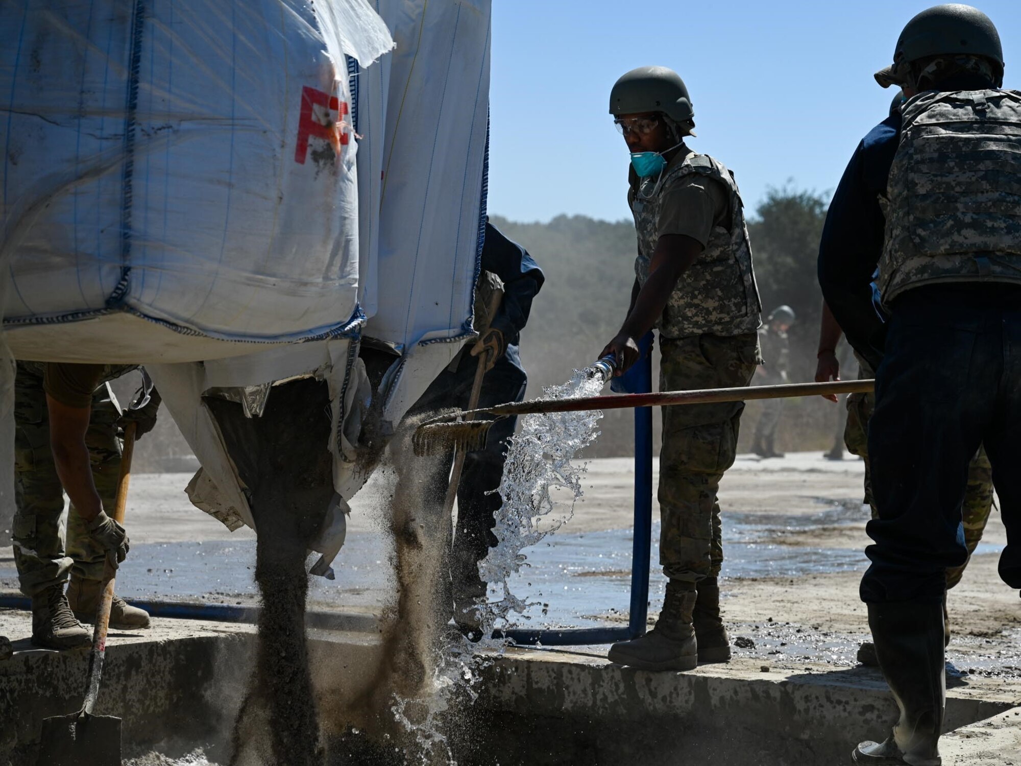 A group airmen mix concrete.