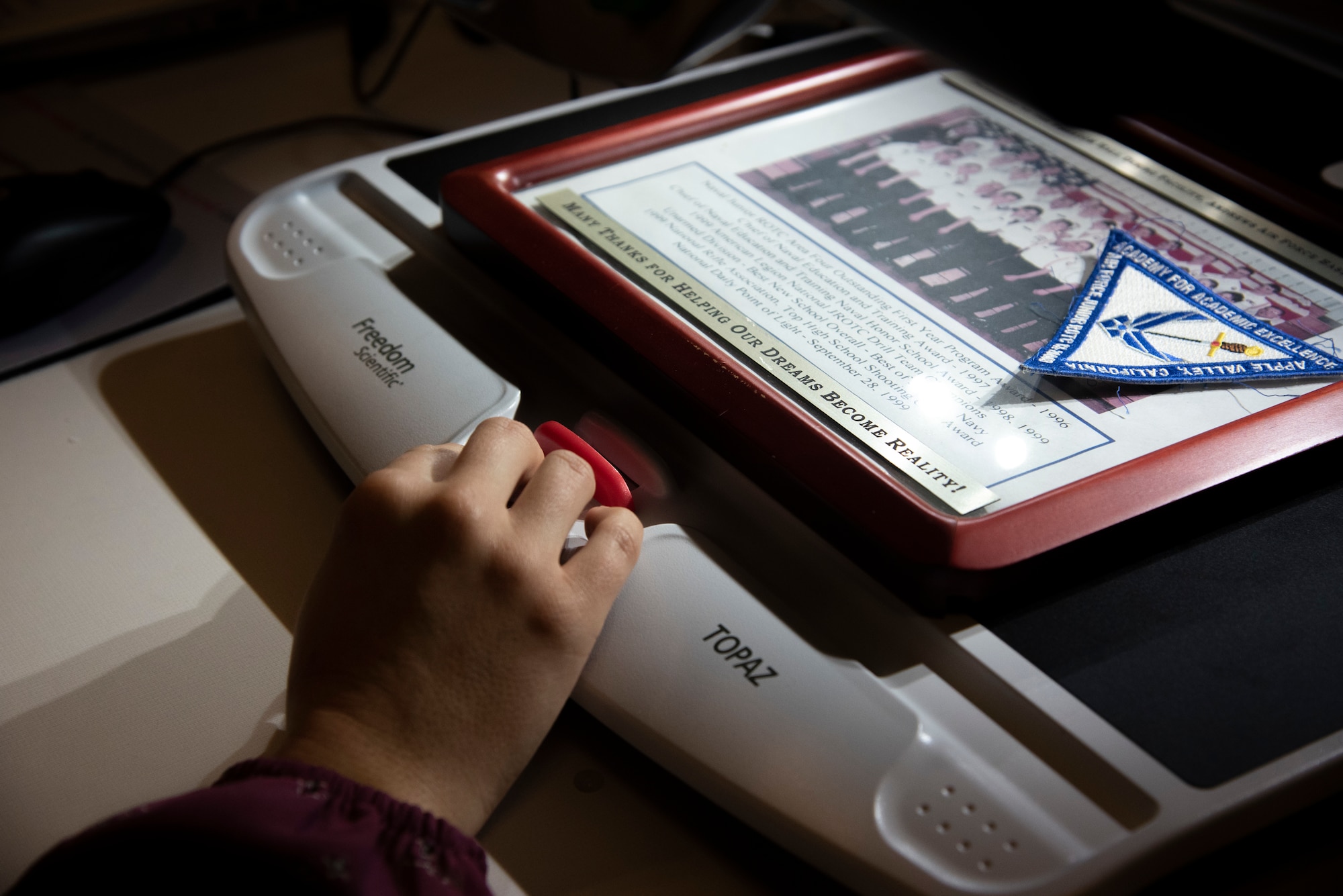 Meaghan M. Kacmarcik, 316th Wing deputy historian, uses a video magnifier device to view items for historical documentation at Joint Base Andrews, Md., Oct. 24, 2024. Due to vision loss caused by Stargardt disease, Kacmarcik uses technology to aid in her work. (U.S. Air Force photo by Patrick Griffith)