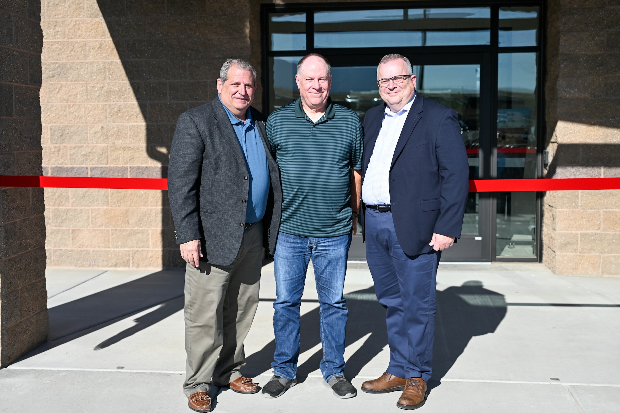 Three men pose for a photo at the dedication ceremony