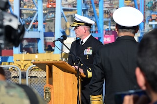 A military officer speaks from a podium.