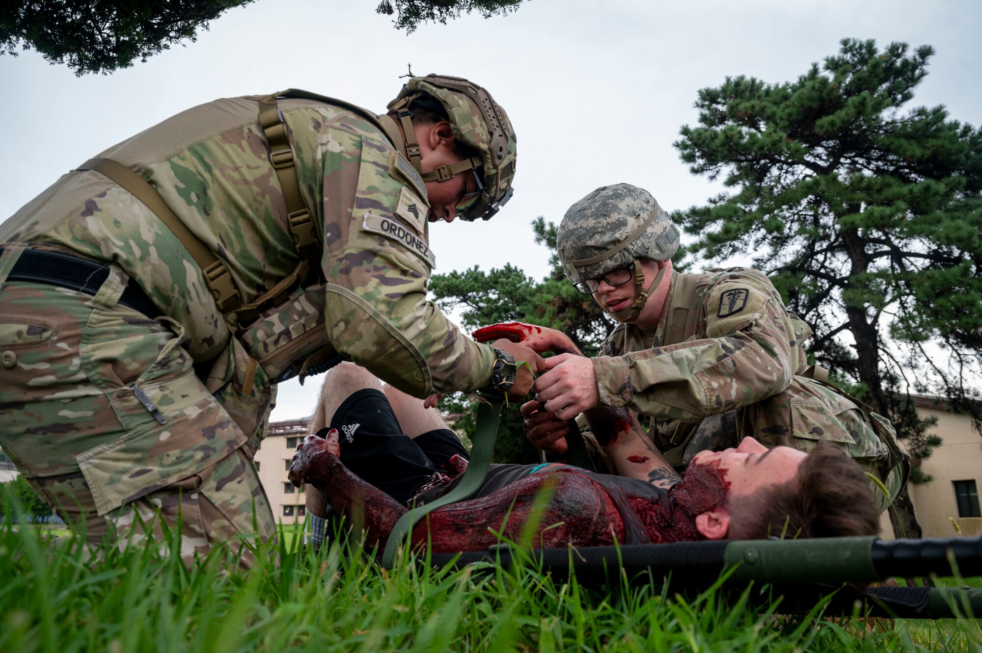 U.S. Army soldiers assigned to the 8th Army, 568th Medical Company, 65th Medical Brigade ground ambulance secure a simulated casualty to a litter during a mass casualty response scenario that was part of  Ulchi Freedom Shield 24 at Osan Air Base, Republic of Korea, Aug. 21, 2024. Regular and realistic mass casualty training provides opportunities to evaluate the functionality of medical equipment, vehicles and communication systems to ensure everything is in optimal condition to execute the mission. This combined exercise highlights the U.S. and Member States ironclad commitment to the alliance in building a robust defense posture to defend the people of the ROK against a spectrum of security threats. (U.S. Air Force photo by Senior Airman Kaitlin Frazier)