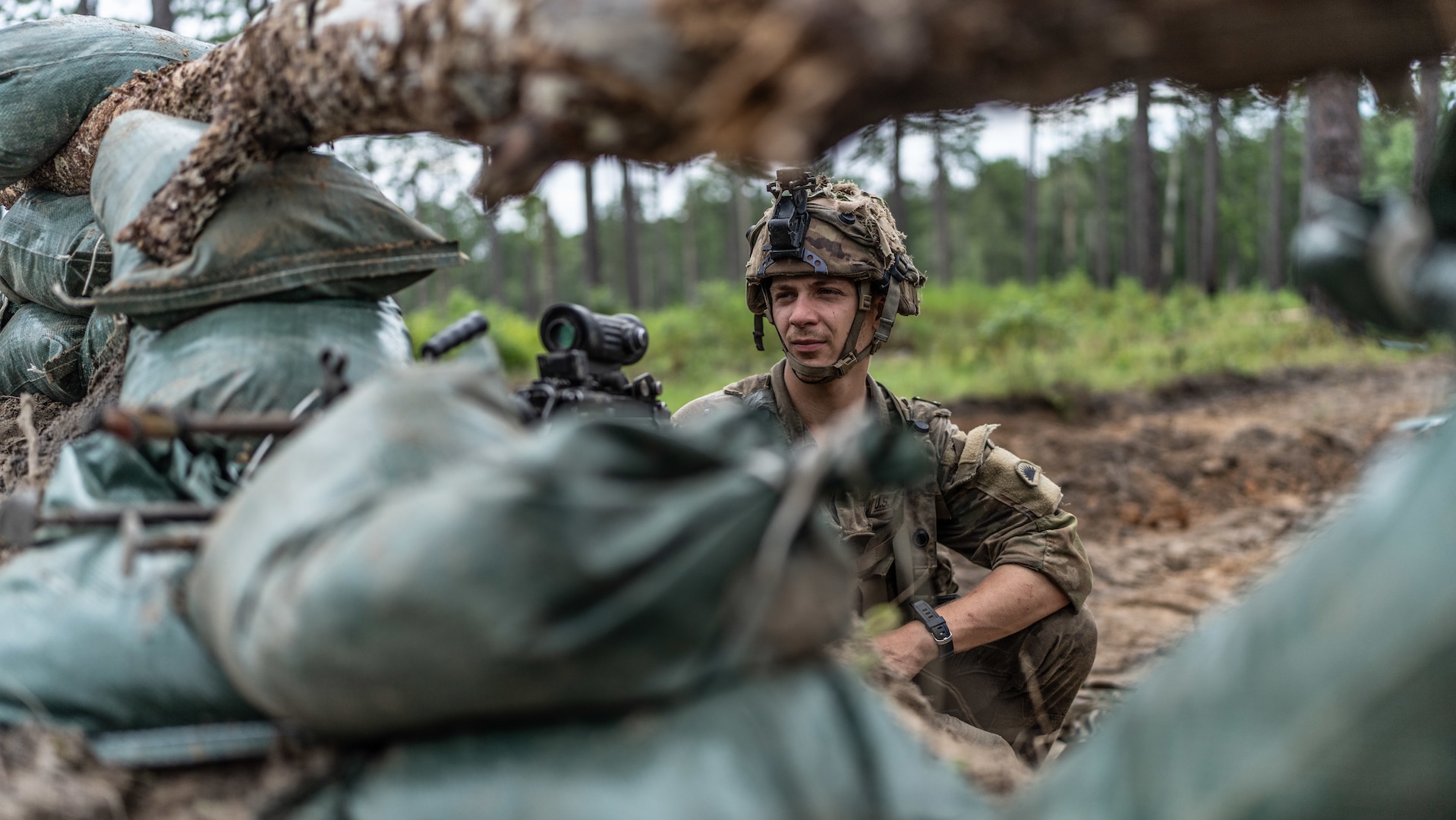 Pfc. Braden Whitlock, an M249 SAW gunner with Alpha Company, 1st Battalion, 186th Infantry Regiment, scans his sector of fire from a newly constructed fighting position during the Joint Readiness Training Center rotation 24-09 at Fort Johnson, La., July 28, 2024. The training exercise focused on large-scale combat operations as part of the 41st Infantry Brigade Combat Team's Annual Training.