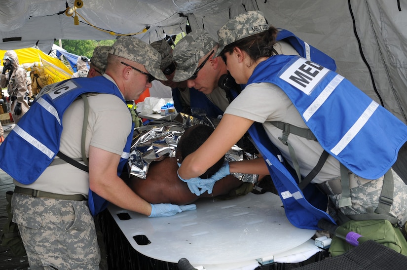 Medics assigned to the Kentucky National Guard's Chemical Biological Radiological Nuclear high-yield Explosive Response Force Package team evaluate a mock casualty during a training evaluation at the Muscatatuck Urban Training Center in Butlerville, Ind., May 23. The joint CERFP includes Army and Air guardsmen who can provide immediate response capabilities to the Commonwealth of Kentucky in the event of a CBRNE incident.