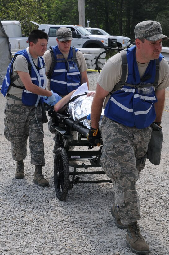 First Lt. Daniel D. Adducchio, Tech. Sgt. John Oliver and Tech. Sgt. Shawn Ingle transport a mock casualty during the Kentucky National Guard's Chemical Biological Radiological Nuclear high-yield Explosive Response Force Package exercise evaluation May 23, at the Muscatatuck Urban Training Center in Butlerville, Ind. The Kentucky Guard's CERFP must validate its mission every two years to achieve National Guard Bureau standards.