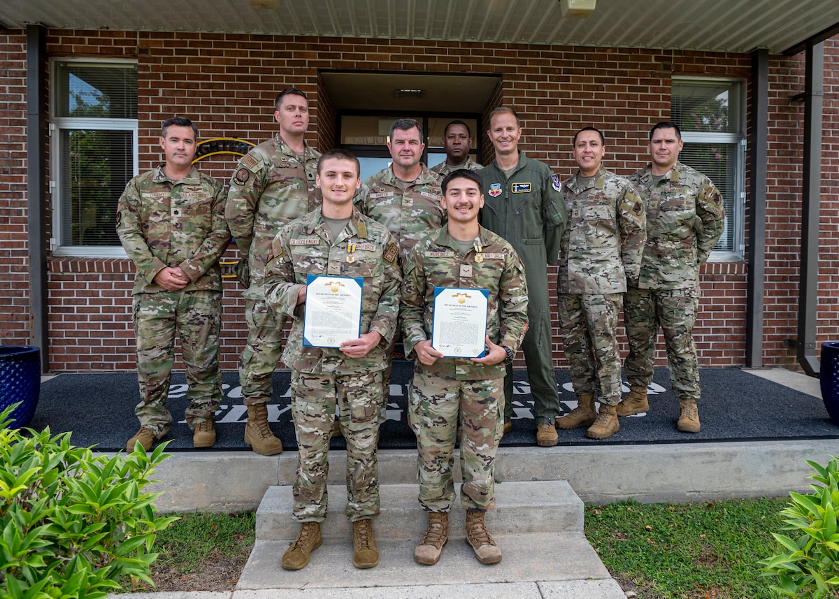 U.S. Air Force Airman 1st Class Trace Drugolenski, 347th Operations Support Squadron commanders enlisted executive, front left, and Airman 1st Class Orlando Martinez, 23rd Operations Support Squadron targeting analyst, front right, pose for a photo after receiving Air and Space commendation medals from Col. Paul Sheets, 23rd Wing commander, center, at Moody Air Force Base, Georgia, Aug. 23, 2024. While on leave in Florida, Martinez and Drugolenski came to aid a drowning victim that ultimately saved his life. (U.S. Air Force photo by Senior Airman Leonid Soubbotine)