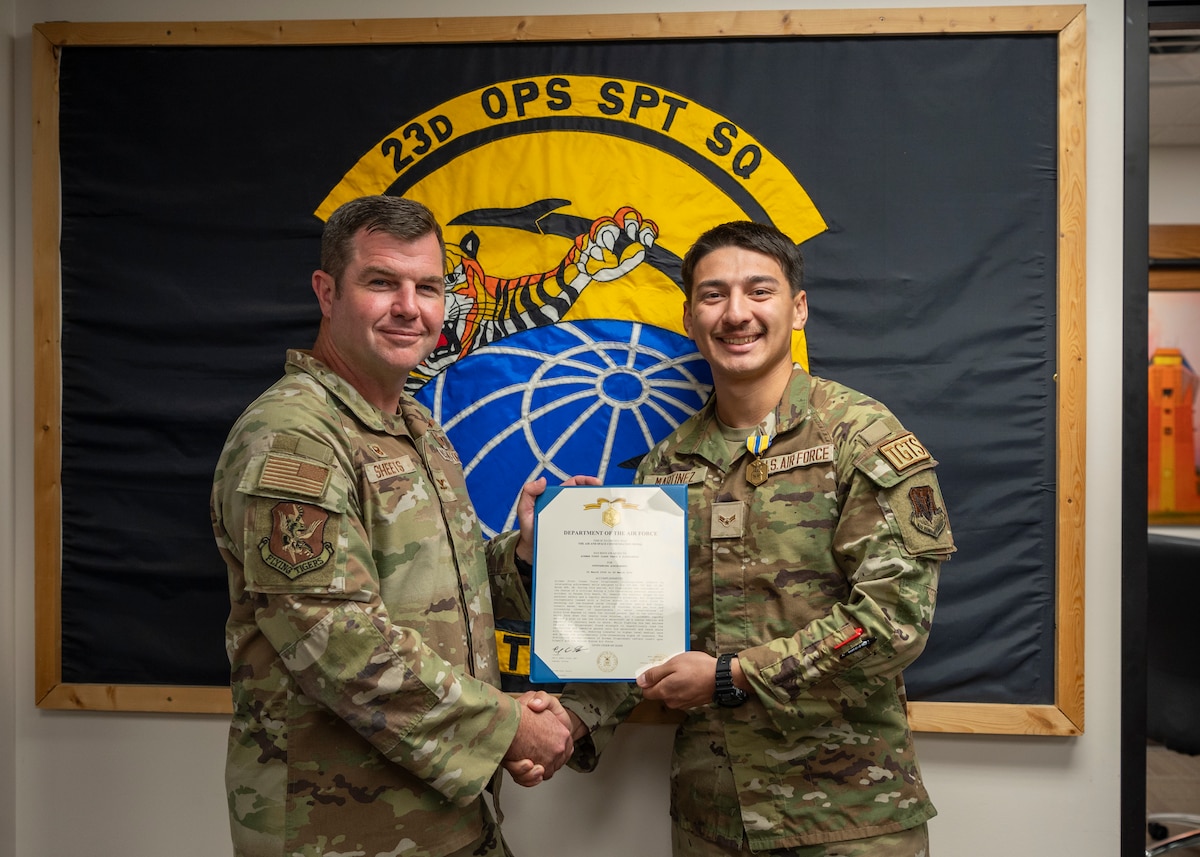 U.S. Air Force Col. Paul Sheets, 23rd Wing commander, left, presents the Air and Space commendation medal to Airman 1st Class Orlando Martinez, 23rd Operations Support Squadron targeting analyst, right, at Moody Air Force Base, Georgia, Aug. 23, 2024. Martinez distinguished himself by coming to the rescue of the drowning victim while on leave. (U.S. Air Force photo by Senior Airman Leonid Soubbotine)