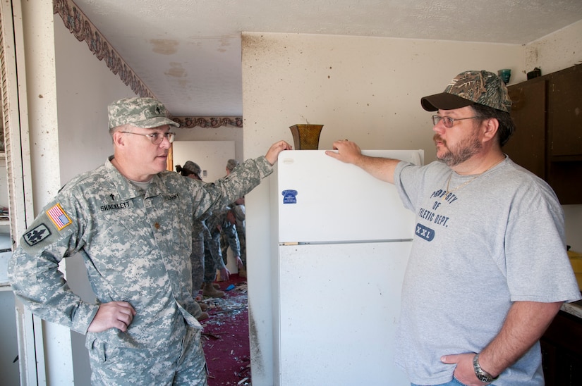 Maj. Jerry Shacklett, a Kentucky National Guard chaplain, talks with Daniel Leach, a West Liberty, Ky., resident, March 7, during clean-up operations following the deadly tornado that ripped through the Eastern Kentucky community, March 2. "Without God's grace we wouldn't have lived through it," Leach said.