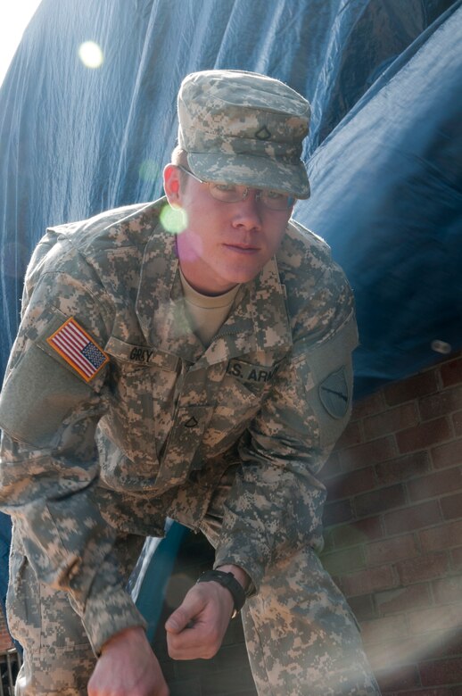 Kentucky National Guard Pfc. Kyle Gray, 301st Chemical Company, pulls nails out of a piece of plywood, March 6, during tornado relief efforts in West Liberty, Ky. Gray boarded up broken windows and holes for West Liberty resident Thomas Coder, a retired Air Force veteran, after a tornado damaged most of his home, March 2.