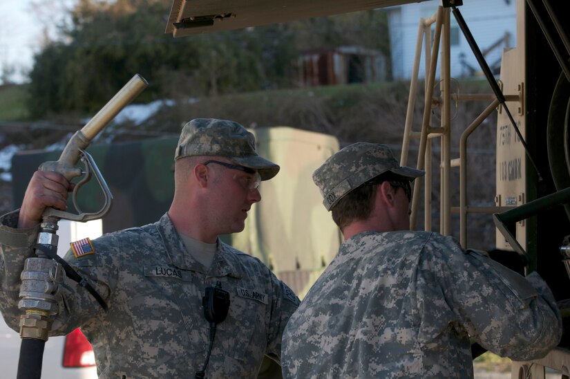 Kentucky National Guardsmen Spc. Gary A. Lucas and Pfc. Lance S. Cox, both assigned to the 299th Chemical Company, prepare to fuel power trucks from the Elliot Electrical Company, March 6, in West Liberty, Ky. The fuel was pumped from Kentucky National Guard M978 Oshkosh Refueler to any vehicle or generator in need of diesel fuel so that relief and clean-up efforts could progress days after a deadly EF3 tornado ravaged the town, March 2.