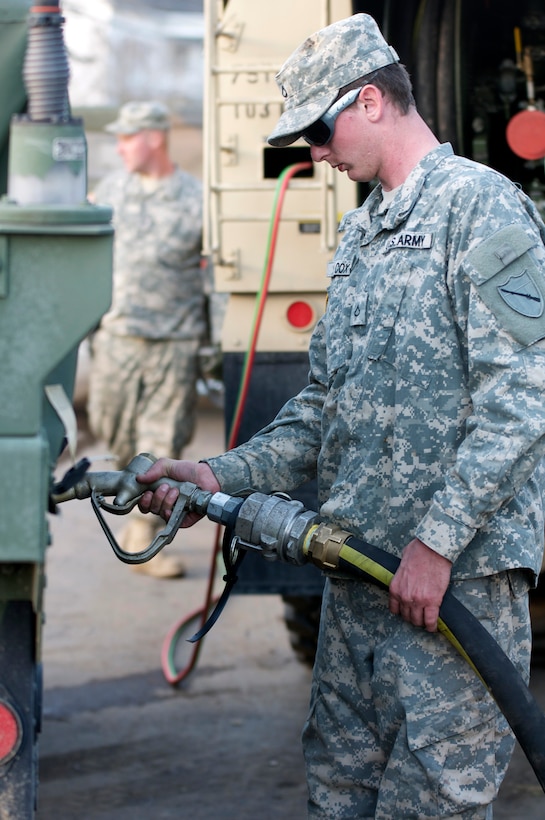 Kentucky National Guard Pfc. Lance S. Cox, a refueler assigned to the Maysville, Ky.-based 299th Chemical Company, fules a Humvee, March 6, in West Liberty, Ky., during tornado relief efforts. Elements from the 103rd Chemical Battalion responded hours after a tornado ravaged West Liberty, March 2, and continued to provide law enforcement and humanitarian support in the week after the storm. Cox's mission was to refuel anything that needed diesel fuel to include generators at the local hospital and incident command trailers as well as military and power company trucks.