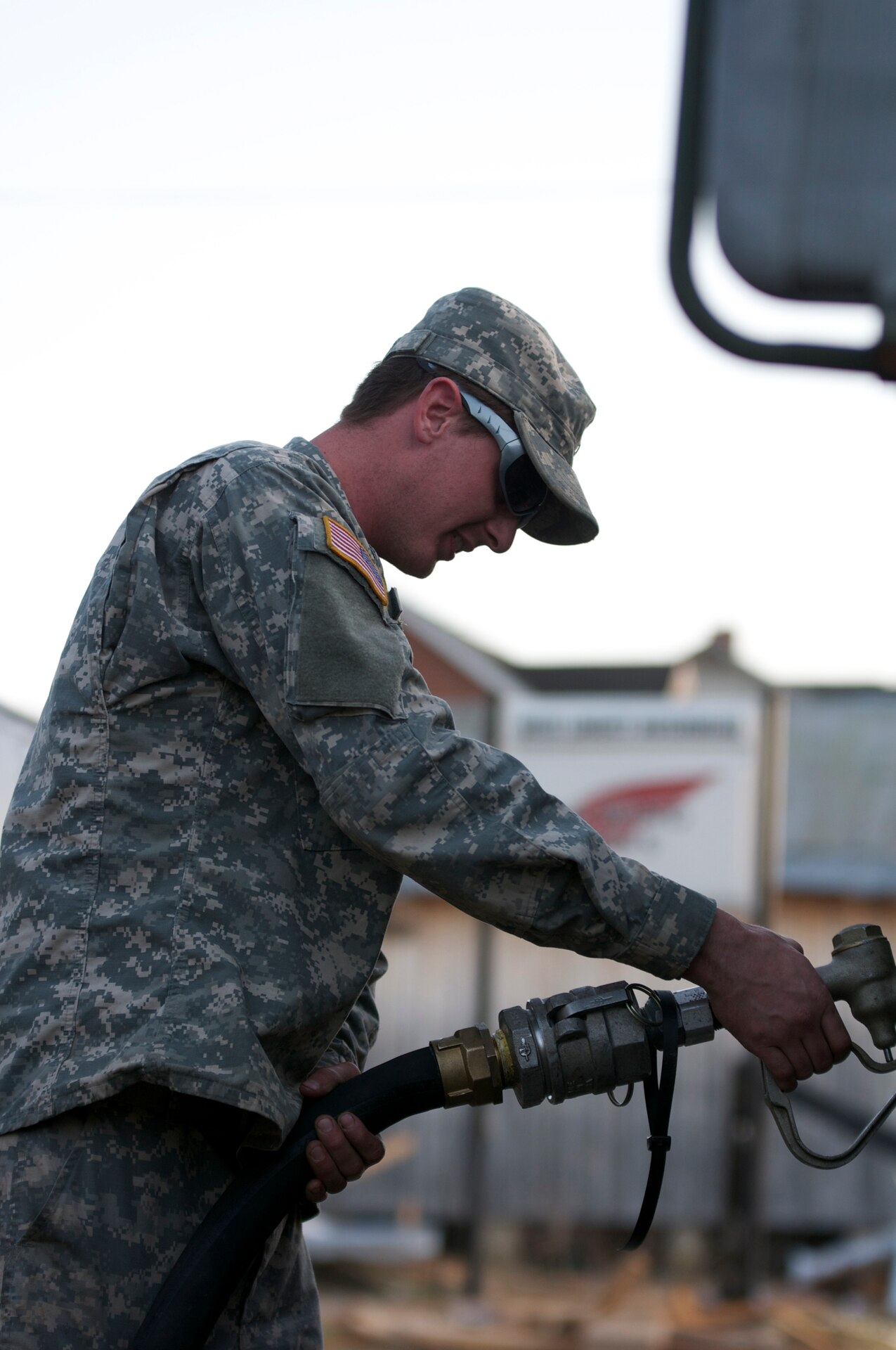 Kentucky National Guard Pfc. Lance S. Cox, a refueler assigned to the Maysville, Ky.-based 299th Chemical Company, fules a Humvee, March 6, in West Liberty, Ky., during tornado relief efforts. Elements from the 103rd Chemical Battalion responded hours after a tornado ravaged West Liberty, March 2, and continued to provide law enforcement and humanitarian support in the week after the storm. Cox's mission was to refuel anything that needed diesel fuel to include generators at the local hospital and incident command trailers as well as military and power company trucks.