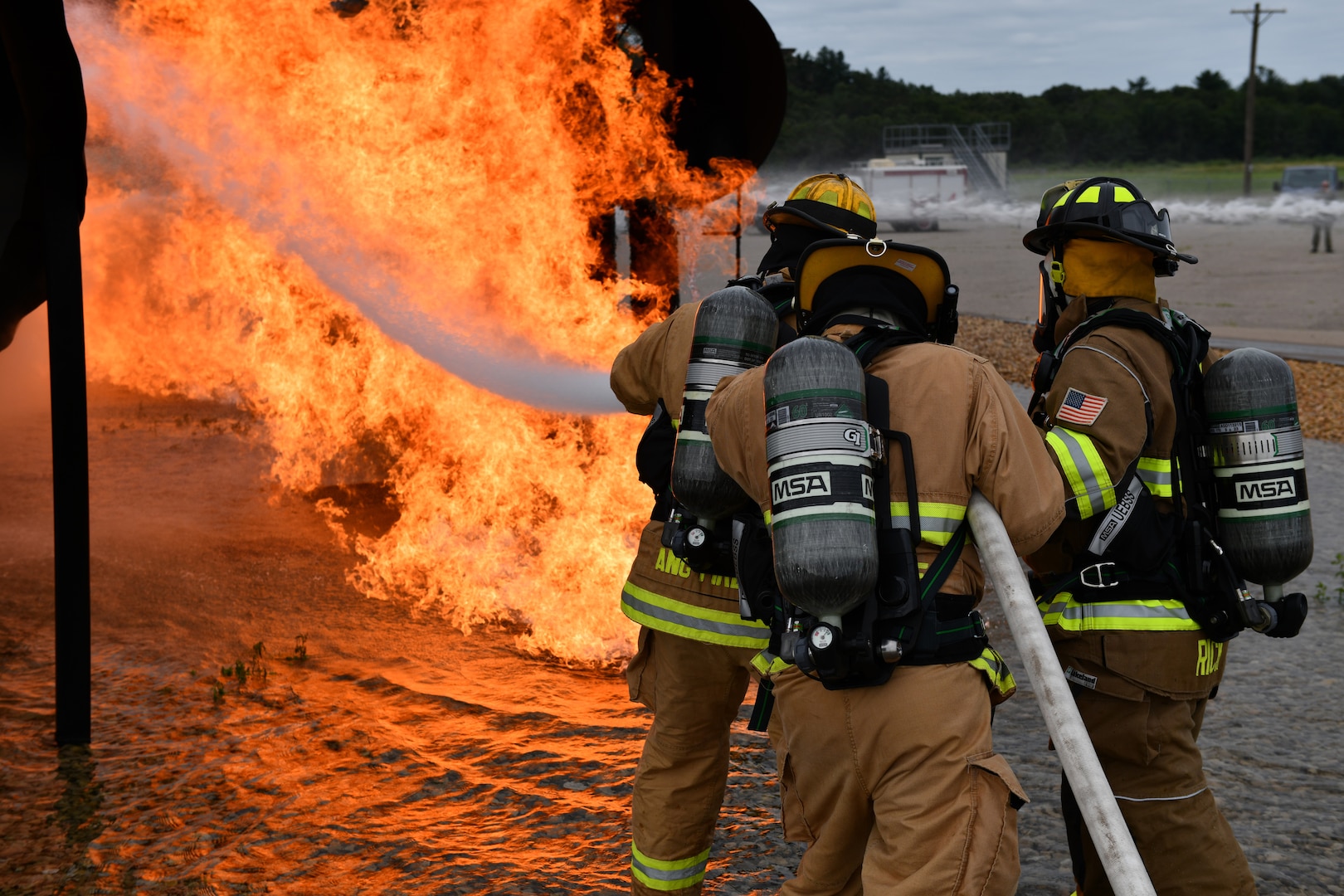 Air Force firefighters assigned to the 178th Wing extinguish a simulated fire Aug. 6 during Northern Lightning, an exercise focused on integrating fourth and fifth generation aircraft, held annually at Volk Field, Wis. Airmen from diverse career fields trained on fire suppression techniques, enhancing their abilities to perform as multi-capable airmen in austere locations in accordance with Agile Combat Employment warfighting concepts. U.S. Air National Guard photo by Airman 1st Class Josh Kaeser