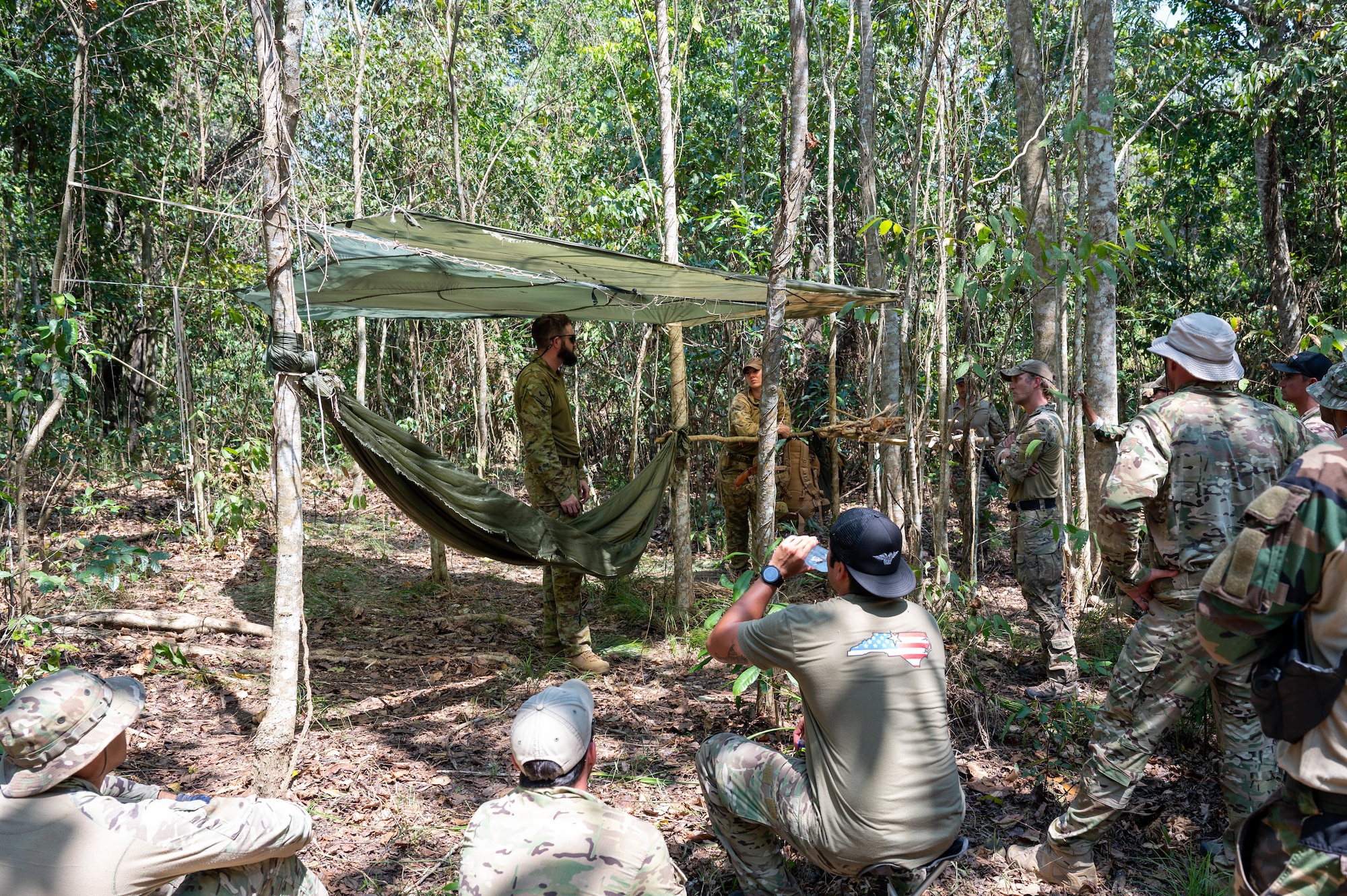 Royal Australian Air Force Cpl. Anthony Ross, Australian Defence Force Combat Survival Training School instructor, discusses the importance of well-built shelter in survival scenarios during Pacific Angel 24-1 at Port Moresby, Papua New Guinea, Aug. 27, 2024. Pacific Angel 24-1 is a bilateral operation with forces representing the U.S. Air Force, Royal Australian Air Force and the Papua New Guinea Defence Force. During the exercise, participants exchanged knowledge and information on various topics including survival, evasion, resistance and escape. (U.S. Air Force photo by Airman 1st Class Carson Jeney)