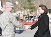 Spc. Matthew Sellers, Horizontal Engineer for the 207th Engineer Battalion, based in Hazard, Ky., shakes hands with Kenna Spears, district leader for Advance Auto Parts in Salyersville, Ky., March 3. Kentucky National Guardsmen from Hazard assisted local residents by directing traffic, aiding in search and rescue missions, and handing out supplies.