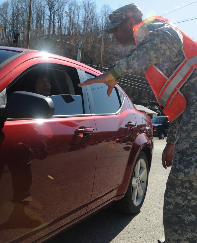 U.S. Army Pfc. Dominique Smallwood, a Chemical, Biological, Radiological and Nuclear specialist with the 299th Chemical Company, out of Maysville, Ky., helps direct traffic in the aftermath of the tornado and series of severe storms that destroyed most of West Liberty, Ky.