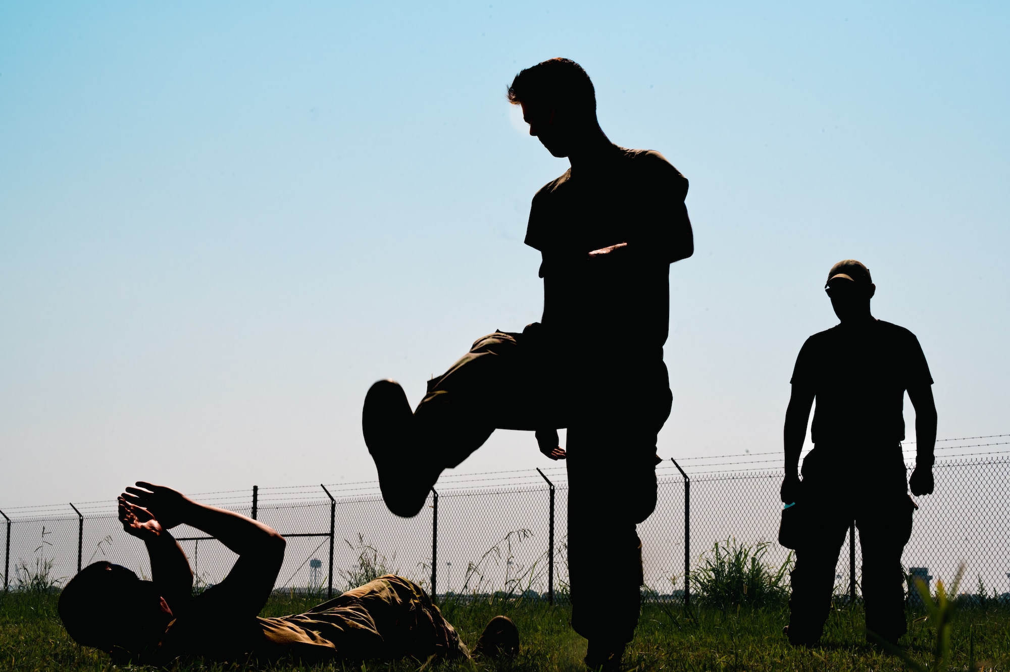 A silhouette stomps towards another silhouette in the grass