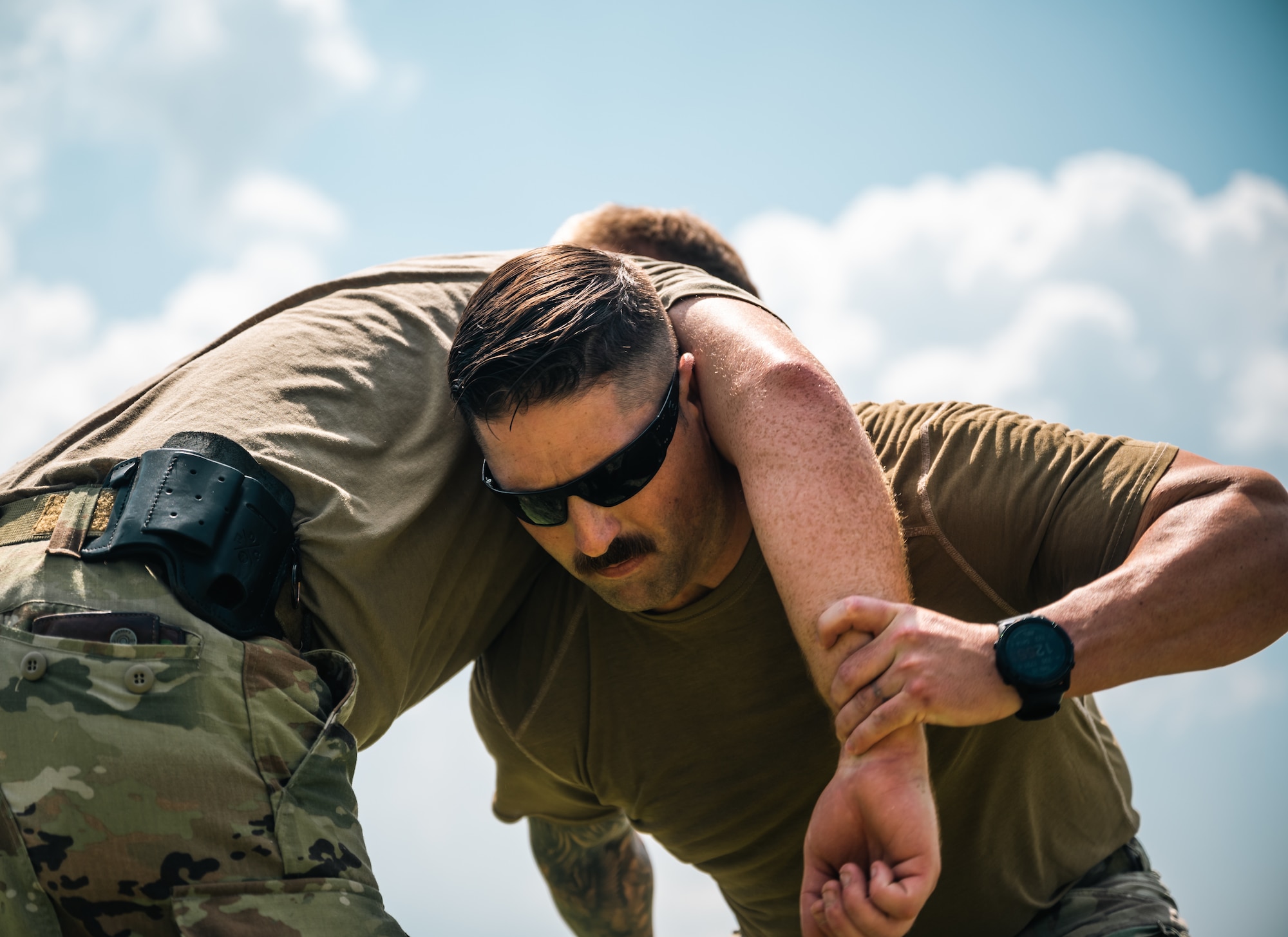 A male Airman grabs another Airman's arm