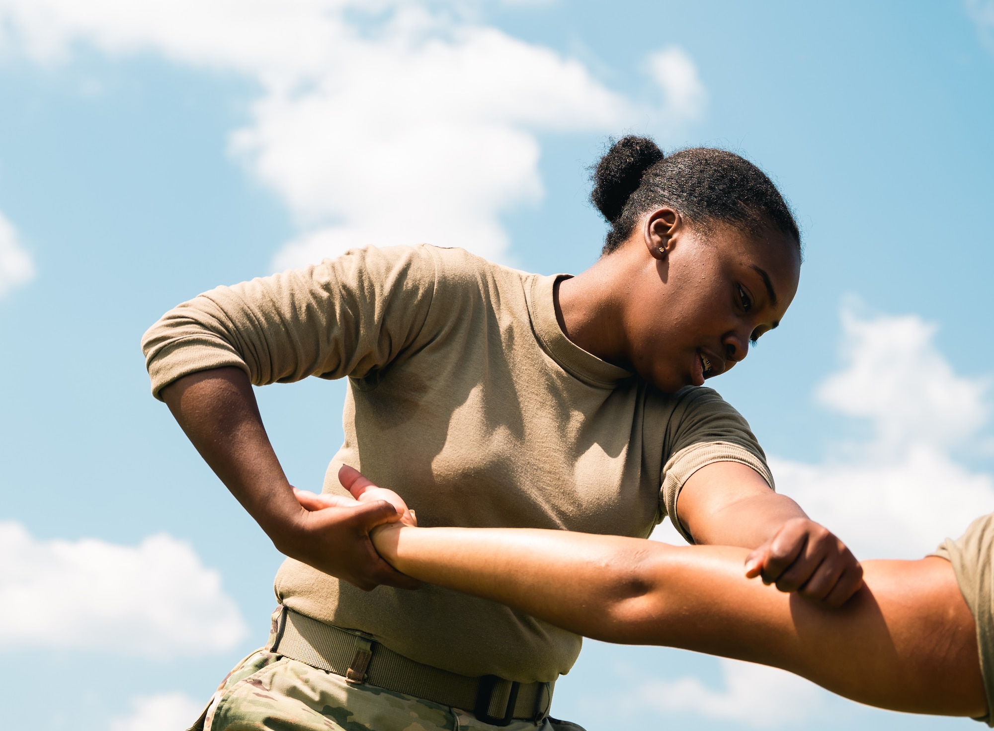 A female Airmen simulates breaking an opponent’s arm