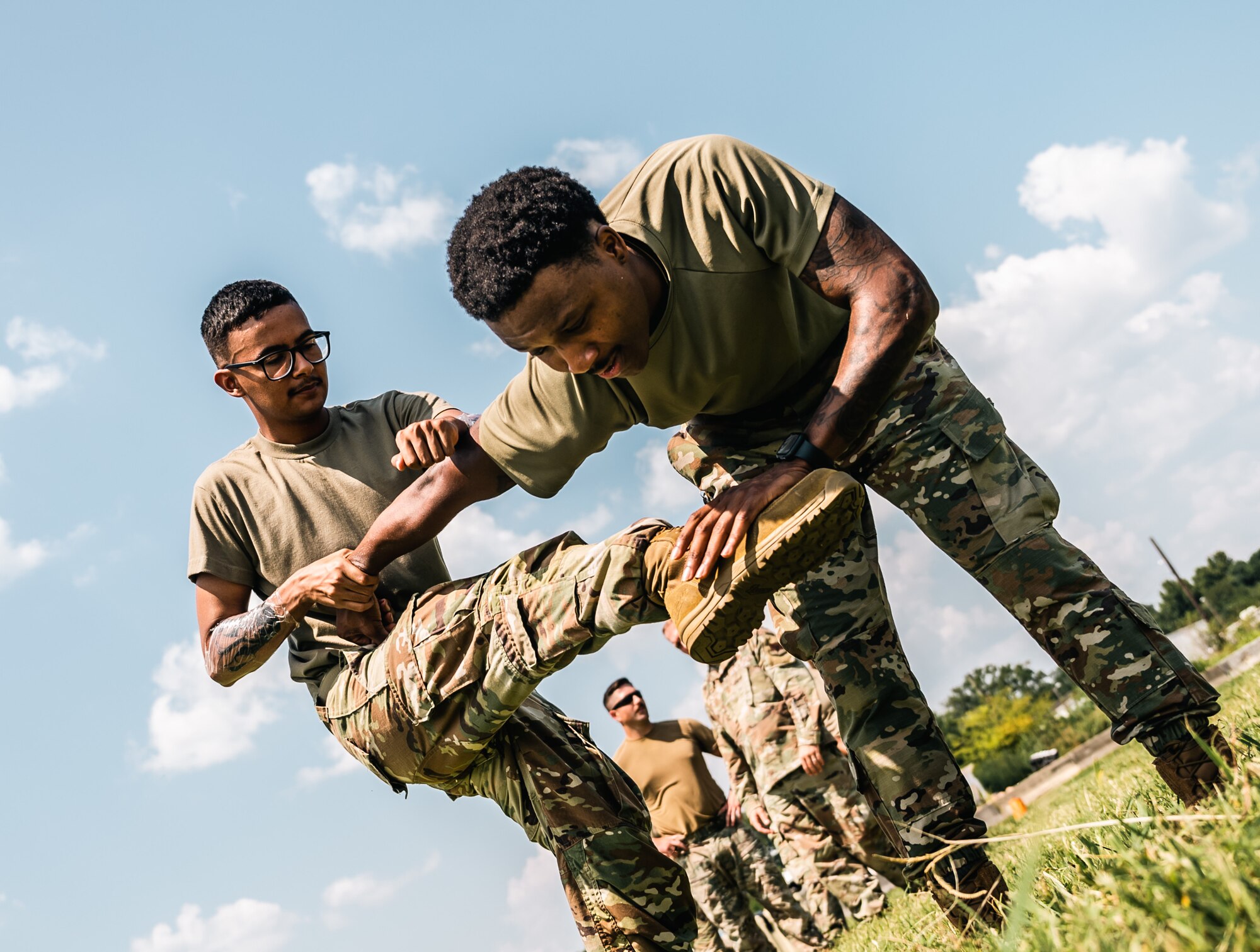 One airmen pulls the arm of another airmen while trying to kick him