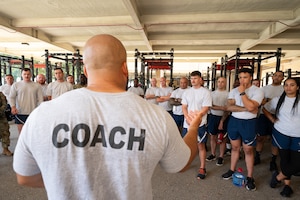 A strength coach speaks to a group of Air Force recruiters