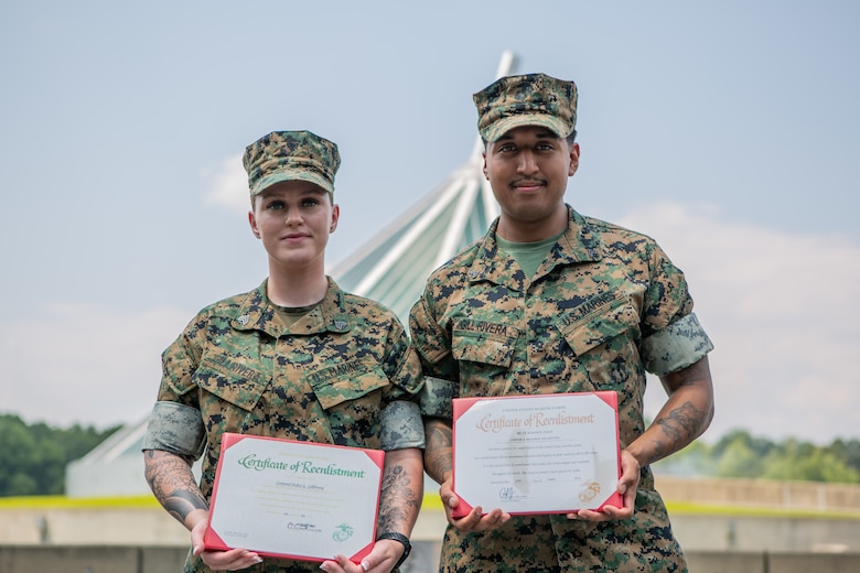 U.S. Marine Corps Sgt. Haley G. Gillrivera, a motor vehicle operator at The Basic School, left, and Cpl. Brandon Gillrivera, a motor vehicle operator at Officer Candidates School, pose for a portrait with their certificates of reenlistment after their reenlistment ceremony at the National Museum of the Marine Corps, Triangle, Virginia, Aug. 1, 2024. The Gillriveras are a dual-military couple who decided to reenlist together, continue to develop their individual careers, and utilize the benefits the Marine Corps has to offer to their family. (U.S. Marine Corps photo by Lance Cpl. Anthony Ramsey)