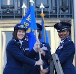 U.S. Air Force Col. Stacy Friesen (left), commander and director of the 316th Medical Group, Joint Base Andrews, passes the 316th Inpatient Squadron’s flag to U.S. Air Force Lt. Col. Falana Gideon, who assumed command of the new squadron on Aug. 23, 2024, making the squadron the first for the Air Force at Walter Reed National Military Medical Center.