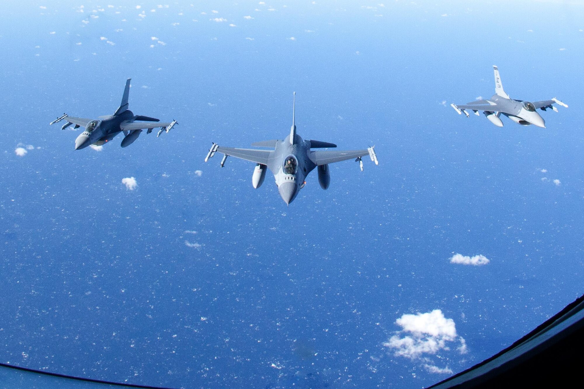 Three F-16 Fighting Falcon from the 121st Fighter Squadron, District of Columbia Air National Guard fly side-by-side in formation.