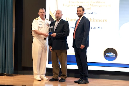 Daniel Shinners, middle, radiological innovation and infrastructure manager, Code 105.7, Radiological Controls Special Projects Division, receives the NAVSEA Excellence in Engineering Award for fiscal year 2023, Aug. 15, 2024, in Washington, D.C. (U.S. Navy photo by Petty Officer 1st Class John Banfield)