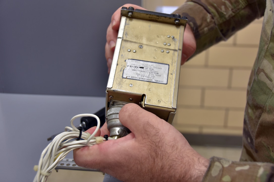 A man holds an aircraft component.