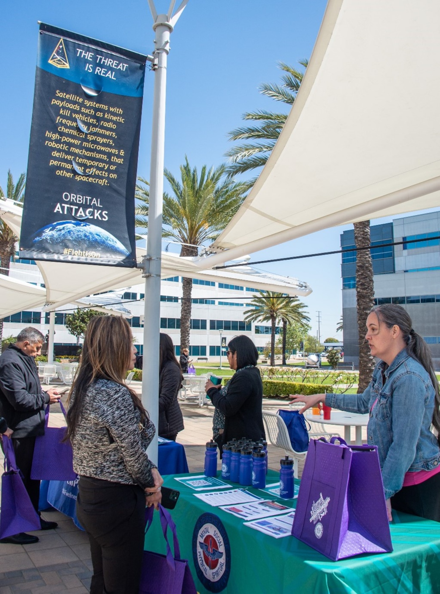 Whitney Easley, right, a prevention analyst with the Los Angeles Air Force Base Resilience Office, staffs a booth providing information on Department of Defense mental health programs at Space Systems Command headquarters event.