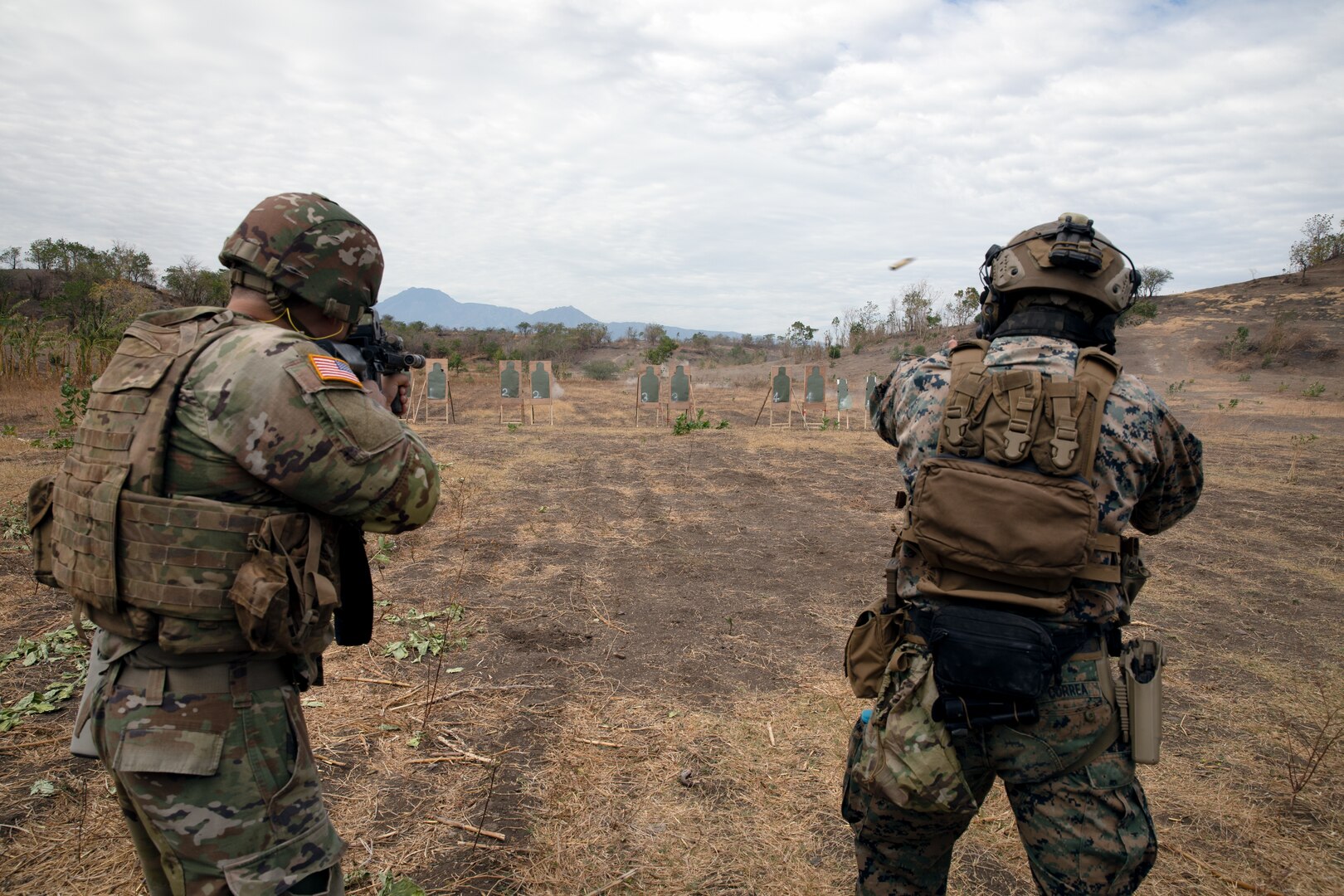 U.S. Army Spc. Thomas Madrzak, a public affairs mass communication specialist with the 368 Public Affairs Detachment, 88th Regional Support Command, and a U.S. Marine fire downrange at a target during a U.S. Marines live fire exercise in Pustalapur 5, Indonesia.