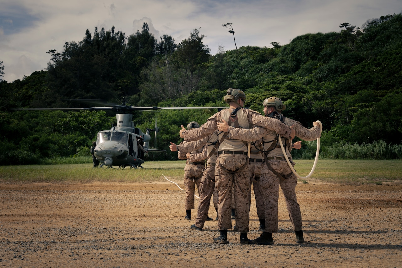 Marines prepare to be lifted in the air from a UH-1Y Venom helicopter.
