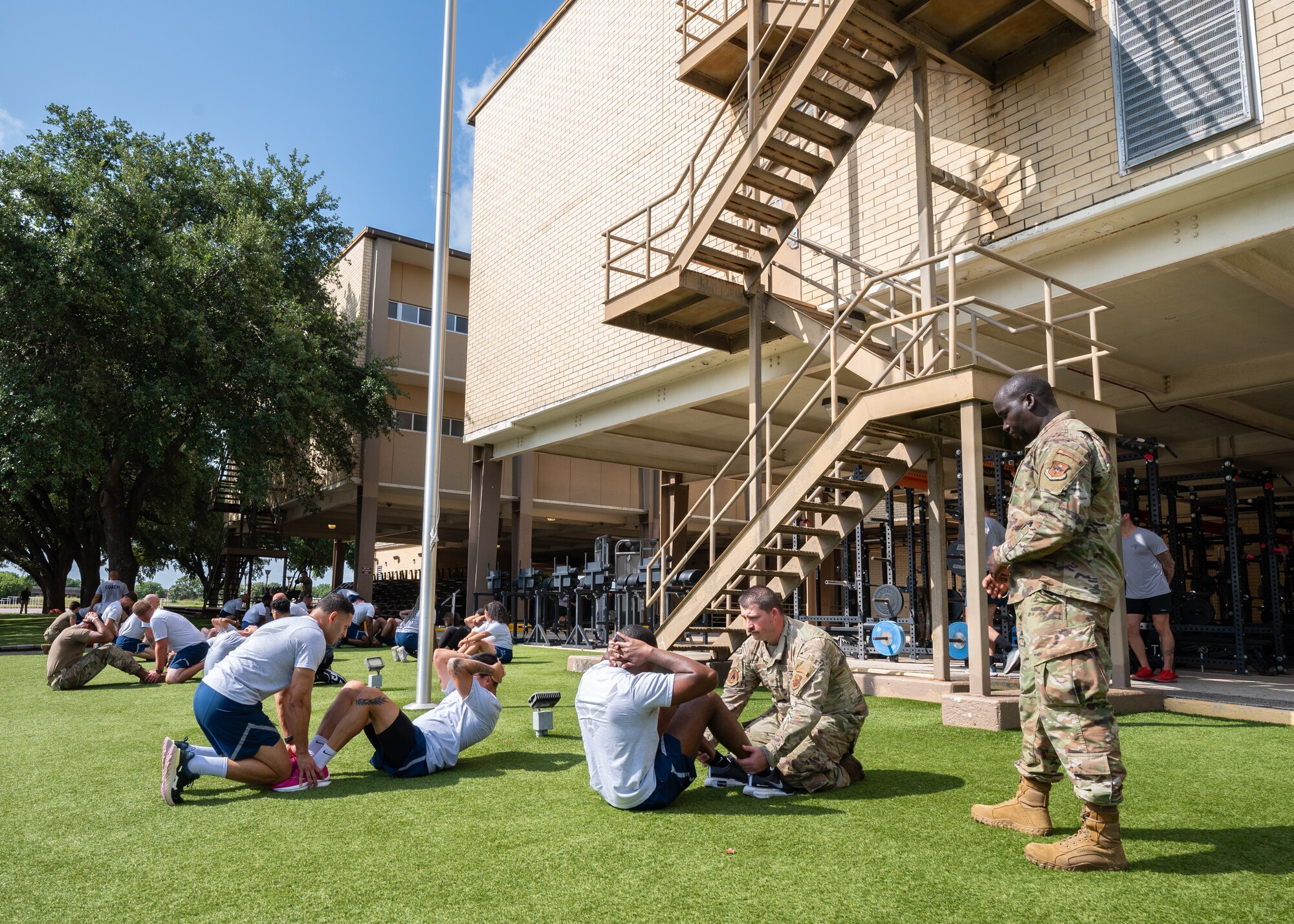 A group of Air Force recruiters conducting sit ups.
