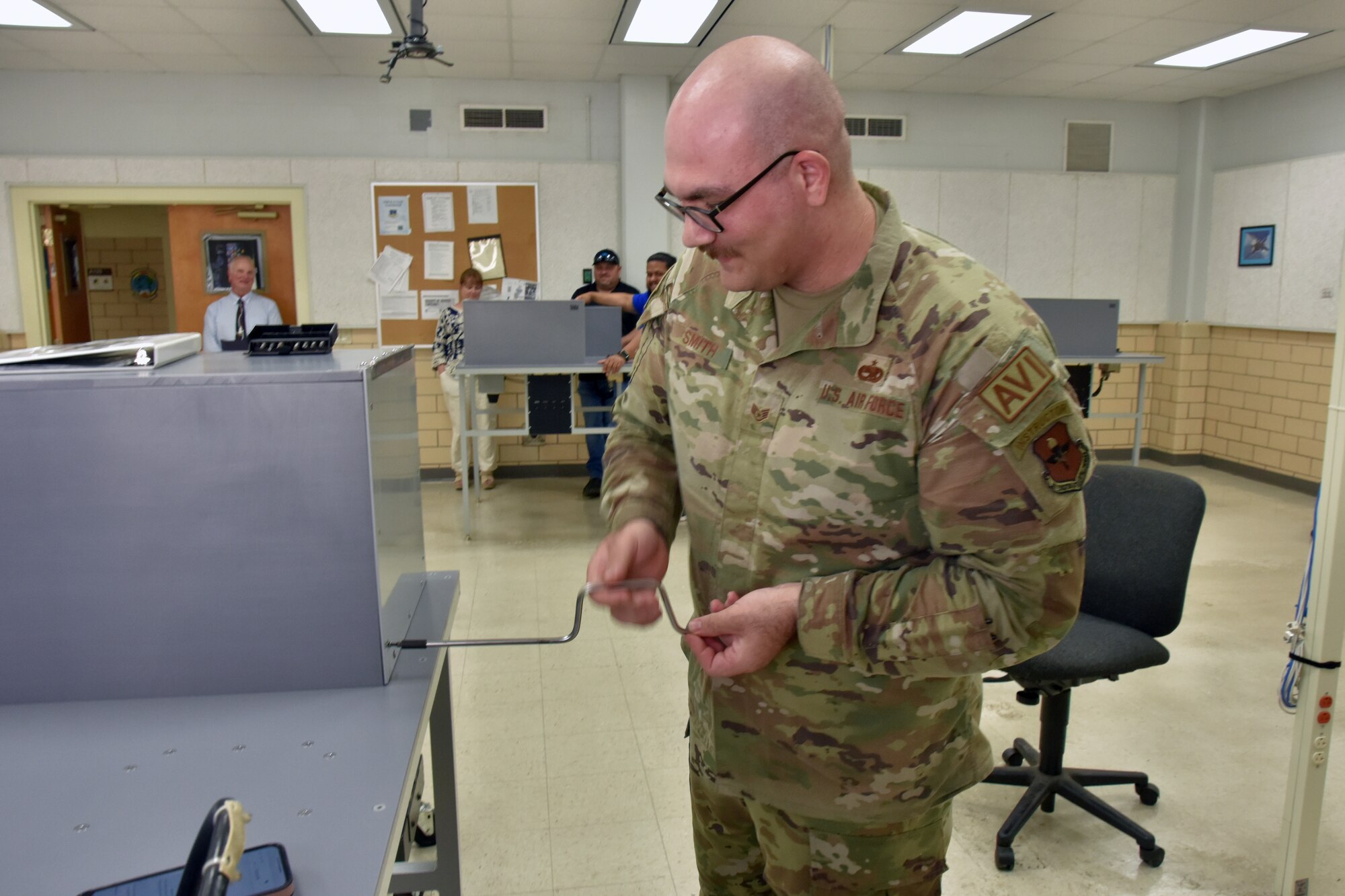 An Airman removes a panel from a training unit.