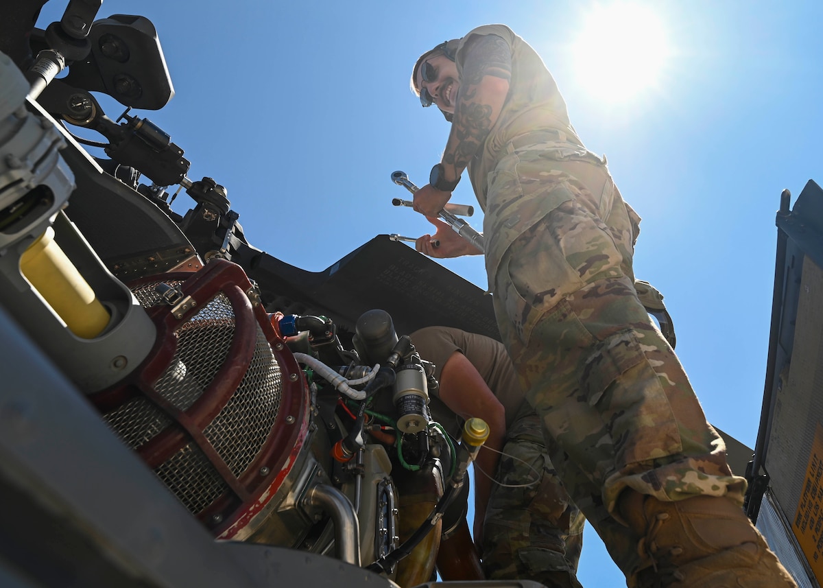 A man in a military uniform works on a plane