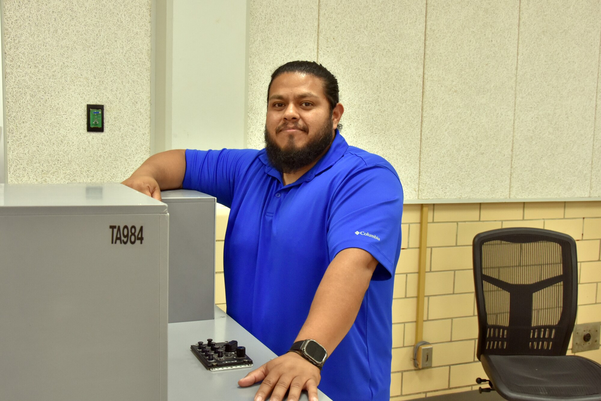 A man stands next to a gray table.