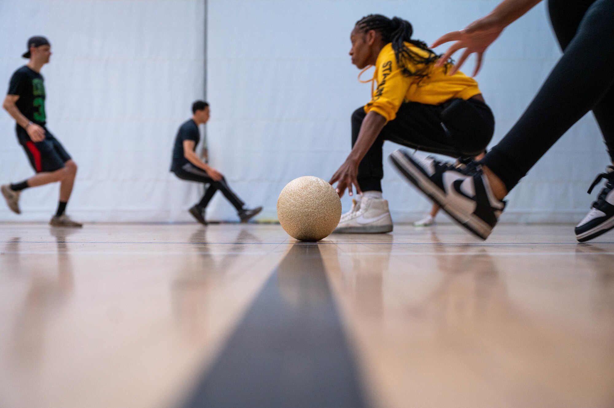 People running to get their dodgeball at the start of a game.