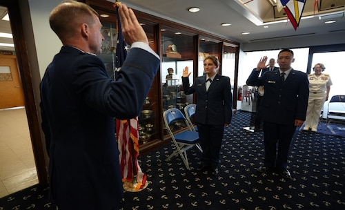 Col. Edward Segura administers the oath of office to Second Lieutenants Kennedy Maddock and Christian Mou at the U.S. Merchant Marine Academy Reserve commissioning ceremony.