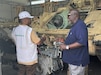 Hiram Gillyard is an Army Expeditionary Civilian Workforce program deployer assigned to Army Field Support Battalion-Germany and serving as the acting director of maintenance at the Coleman Army Prepositioned Stocks-2 worksite in Mannheim, Germany. Pictured here, Gillyard (on right) speaks to an APS-2 contractor at the Coleman worksite. (U.S. Army courtesy photo)