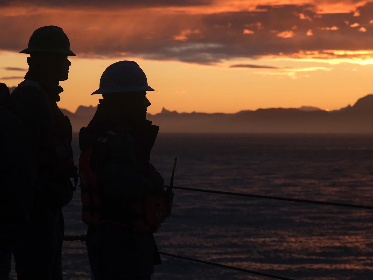 U.S. Coast Guard Cutter Northland (WMEC 904) crew members watch the sunrise, Aug. 24, 2024, near Nuuk, Greenland. The Northland made the trip to Greenland as part of Operation Nanook, a Canadian-led exercise to strengthen partnerships of allied nations committed to the protection of the Arctic region. (U.S. Coast Guard photo by Petty Officer 3rd Class Anthony Randisi)