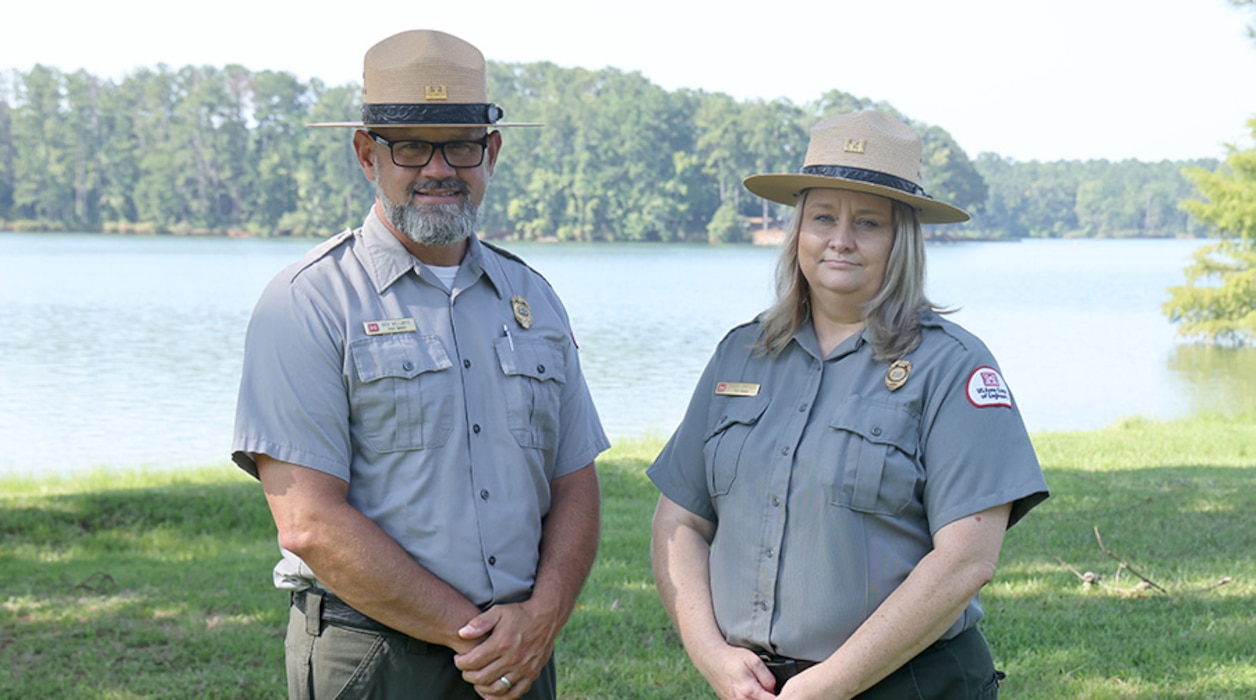 Male and Female Ranger standing in front of a lake.