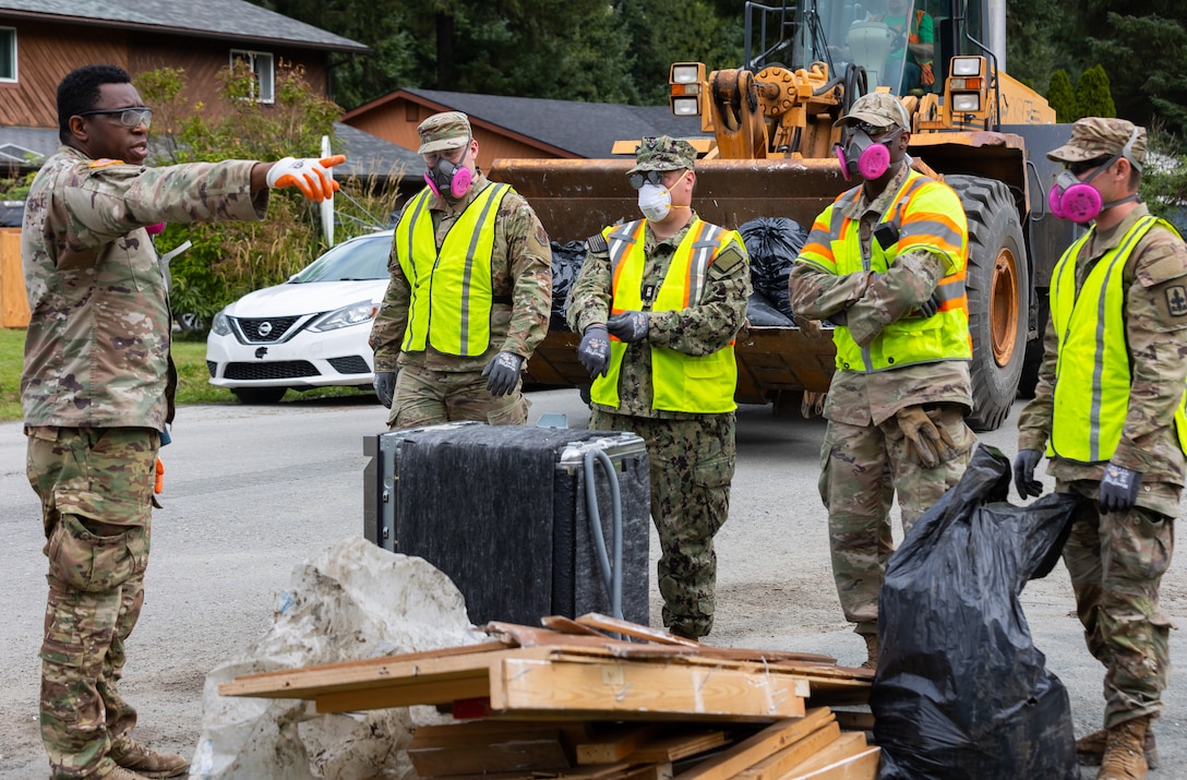 Service members with the Alaska Air, Army National Guard, and Naval Militia clear debris off the road while assisting local authorities and tribal emergency operations personnel in the Mendenhall Valley, Juneau, Alaska, Aug. 14, 2024.